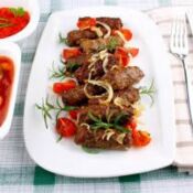 Cevapcici auf einem fruchtigen Tomatensugo mit Erbsenreis 